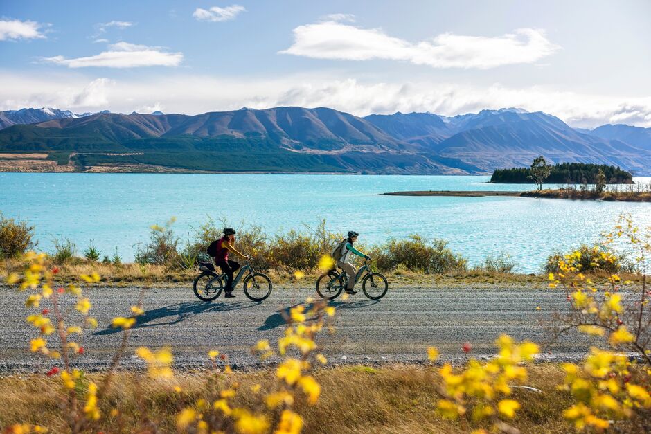 Cyclist passing by Lake Takapō on the Alps 2 Ocean Cycle Trail