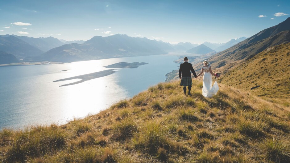 Happy couple taking in the stunning views overlooking Lake Wakatipu