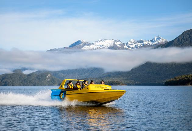 Rase bei einer aufregenden Fahrt mit dem Jetboot durch enge Schluchten mit Blick auf die Berglandschaft. Hier erfährst du, wo du in deinem nächsten Neuseeland-Urlaub Jetbootfahren kannst.
