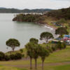 Blick auf die Mündung im Hafen von Whangaruru mit ruhigem Wasser und Aktivitäten wie Wandern, Schwimmen und Bootfahren.