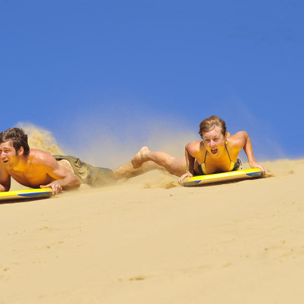在赫基昂加（Hokianga）的沙丘上体验滑沙板的乐趣