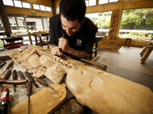 In Te Puia, Rotorua, kann man den Schnitzmeistern der Maori bei der Arbeit zusehen. Die Kunst wird von einer Generation zur nächsten weitergereicht.