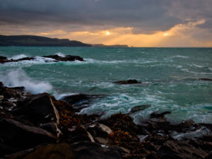 Sun rising through the clouds over the bay