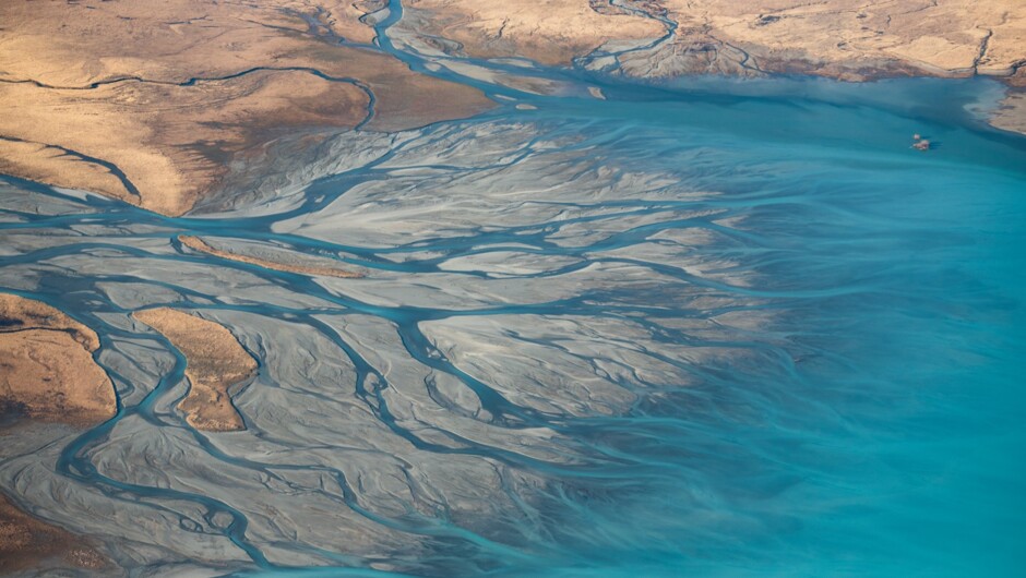 See unique and beautiful braided rivers. Pictured: the Godley River flowing into Lake Tekapo.