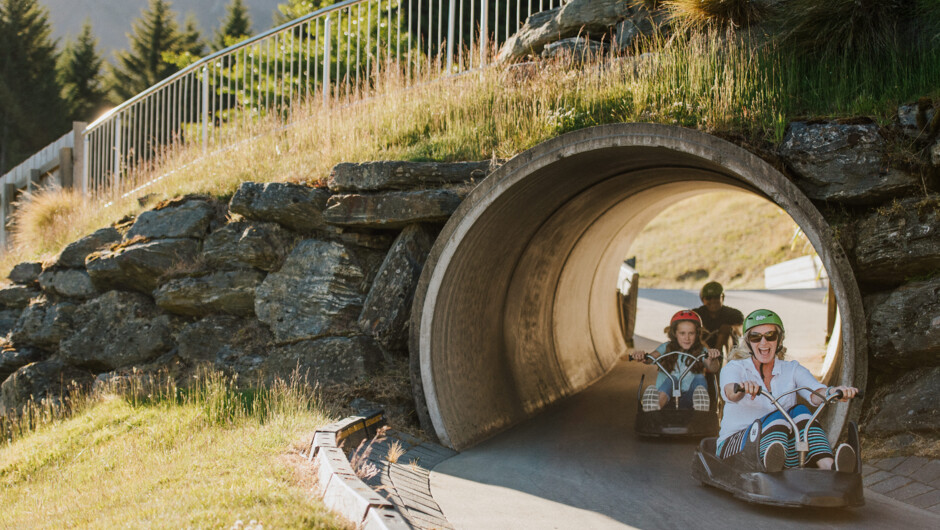 A family races through a tunnel on the Blue Luge track.