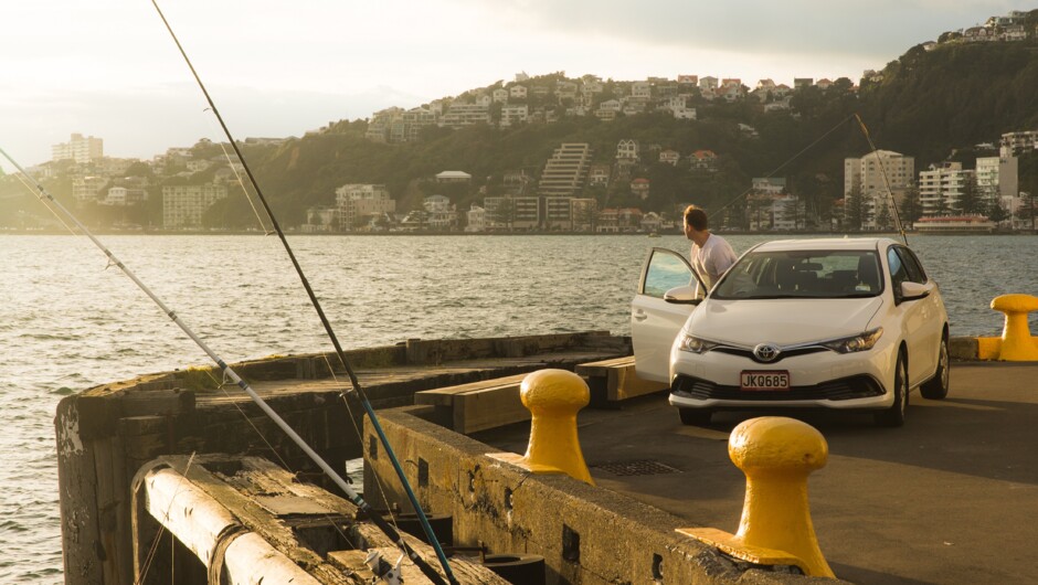 A man getting out of his GO Rentals vehicle parked up beside the Wellington Wharf.