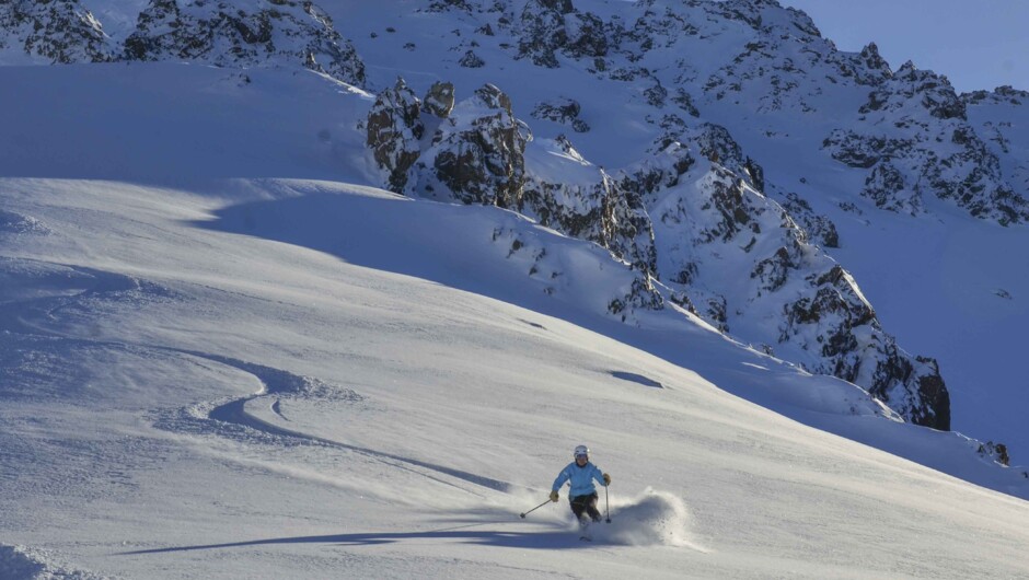 백컨트리 지형의 앨런스 베이슨에서 신선한 눈 위를 활강하는 스키어.