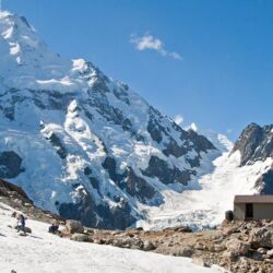 Caroline Hut, dwarfed by the 2000m high Caroline Face of Aoraki Mt Cook.