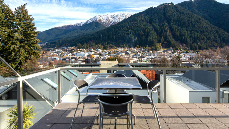 Large balcony/terrace with outdoor table and views over Queenstown.