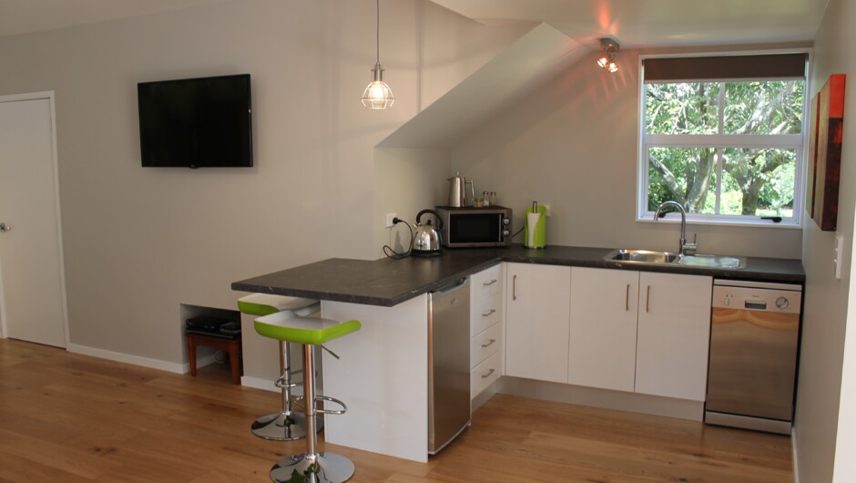 Kitchenette with breakfast bar, microwave, sink, fridge/freezer and dishwasher. 42&quot;TV and DVD player on the wall.