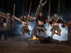 Warriors perform a haka with taiaha weapons at Tamaki Maori Village, Rotorua
