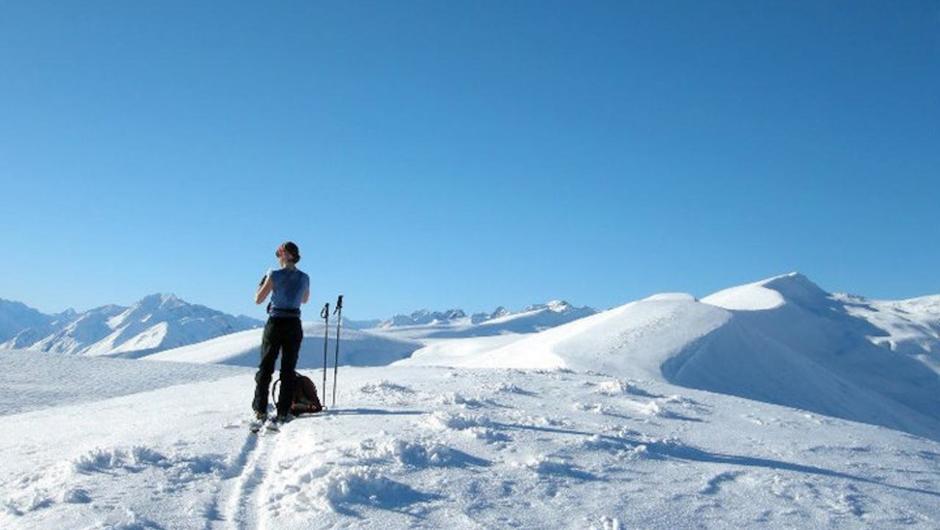 A nordic ski tourer pauses for a photo on Snake Ridge, Lake Tekapo High Country