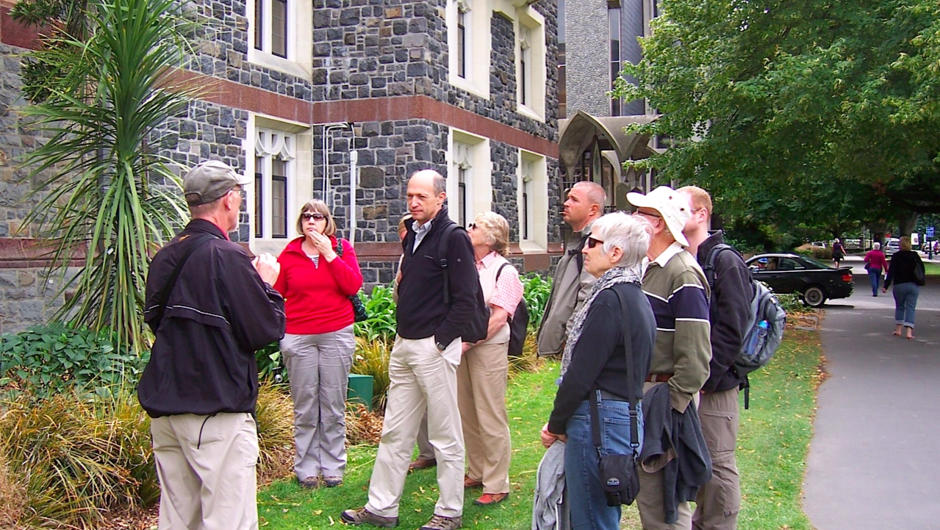 Guide discussing heritage building with walkers