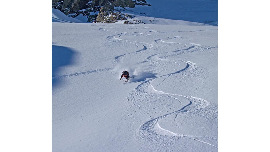 An expert Telemarker shreds the pow at the top of the Tasman Glacier on a 6-day ski touring trip based at Kelman Hut