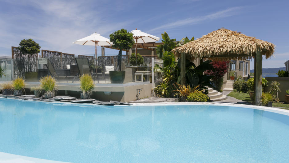Pool area with heated swimming pool and thermal spa pool and patio with furniture