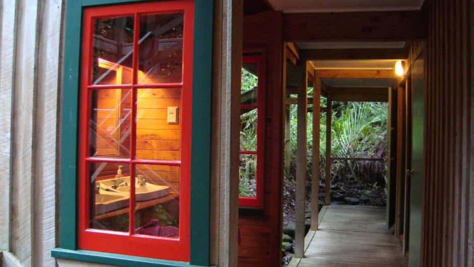 The bathroom facilities are joined by a wooden walkway in lush subtropical gardens.
