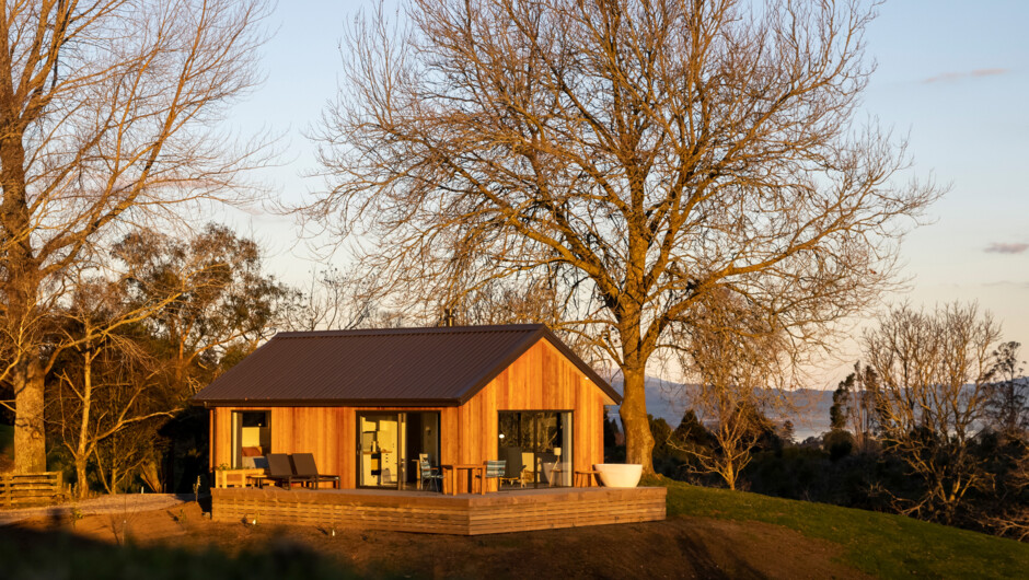 Wildberry Cottage bathed in a winter sunset with Lake Rotorua in the background