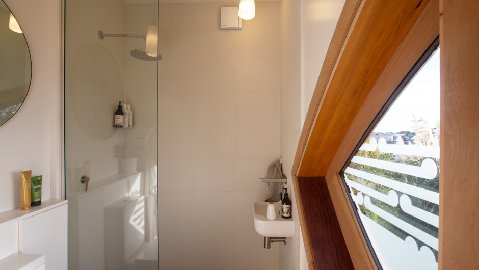 Iona's fresh modern bathroom - shower and fittings in a fresh, roomy setting looking out to the river.