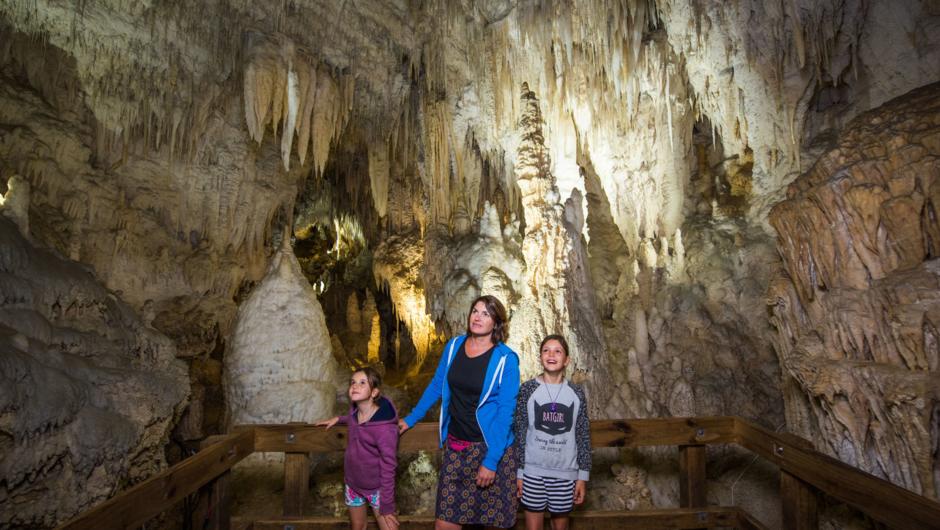Family in awe looking up to some of the Aranui Cave formations.