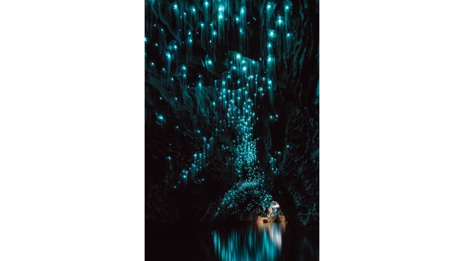 Glowworms reflecting off the water in an underground cave.