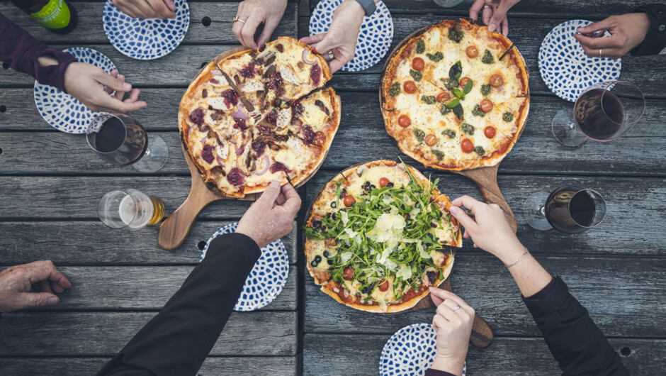 Sharing fresh, hot stone-baked pizzas at Punga Cove jetty