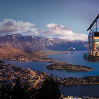 The night time view of the Skyline Queenstown complex from an outdoor seating area.