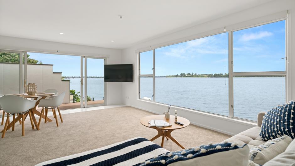 Living Room.  We offer Free WIFI and Netflix to enjoy on your brand new 54” Smart TV. Relax and kick back on the couch, watch your favourite Netflix series while enjoying the waterfront view.