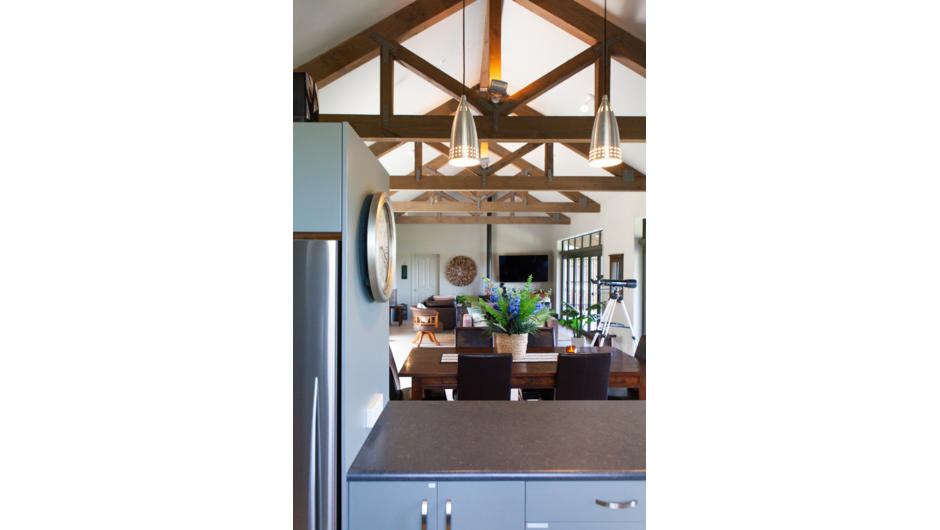 Central open timber beams emphasise the easy movement between indoor living and natural surrounds.