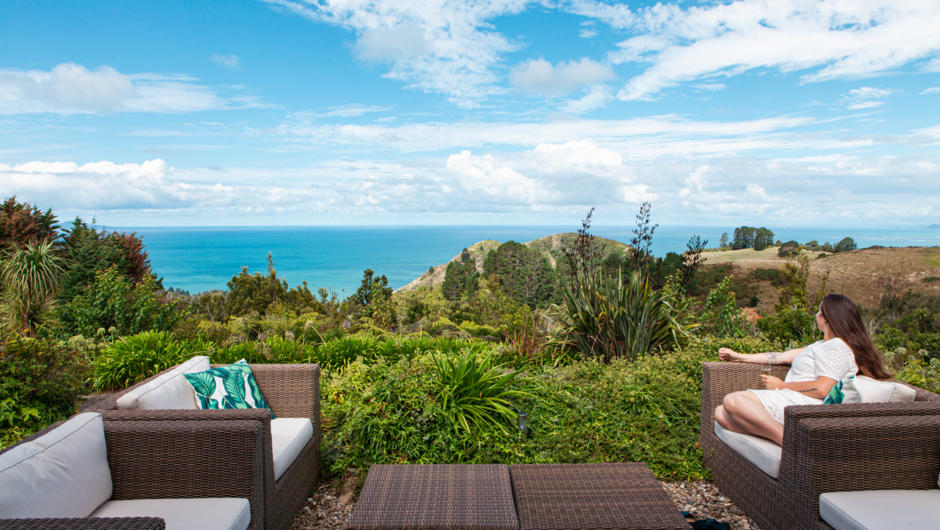 Enjoy stunning coastal views from the comfort of outdoor seating at Orokawa Bay Retreat.