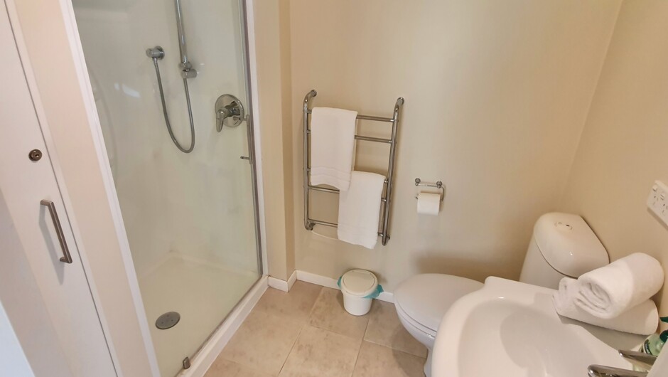 Main bedroom ensuite bathroom with shower, hair dryer, heated towel rails & wall heater.