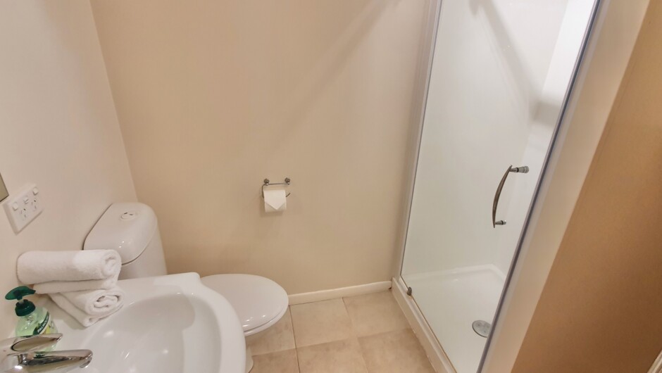 Bedroom 2 ensuite bathroom with shower, hair dryer, heated towel rails & wall heater.