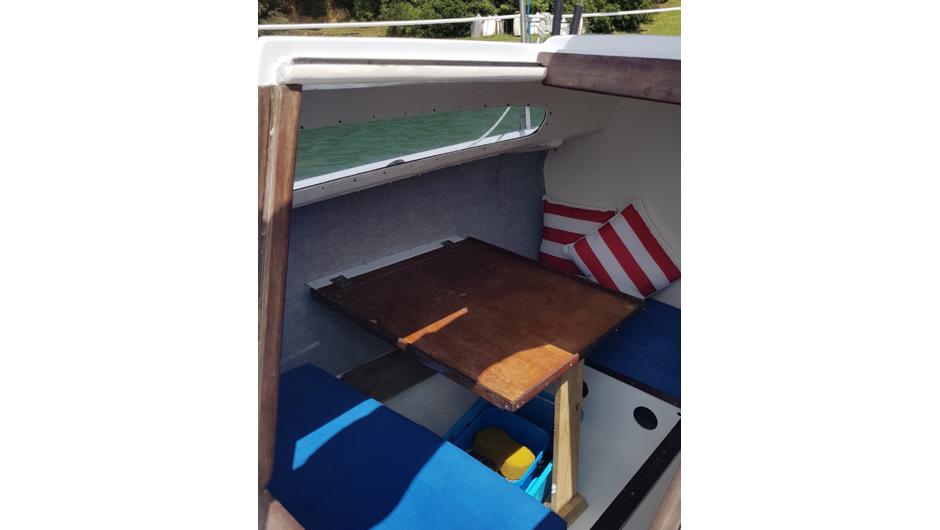 Table on starboard side drops down to form a double bunk.