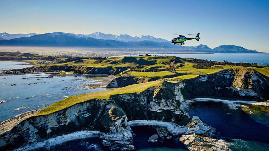 South Pacific Helicopters EC120 over Kaikōura Penninsula and Seaward mountain range in the background.