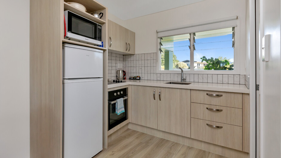 Full kitchen available in our newly renovated one and two-bedroom units. The kitchen includes a 2 burner ceramic cook top and an under bench oven, a fridge/freezer and a microwave.
