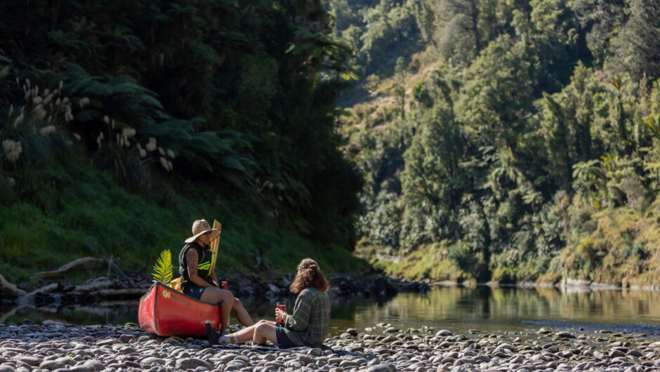 Paddlers pause for a rest on the riverbank of Te Whanganui Awa