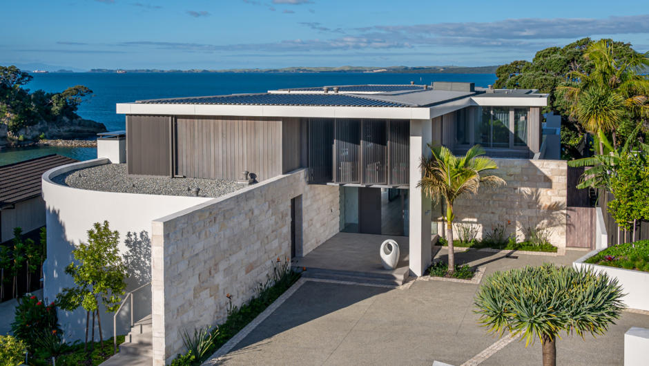 Exterior of property with the Hauraki Gulf in the background.