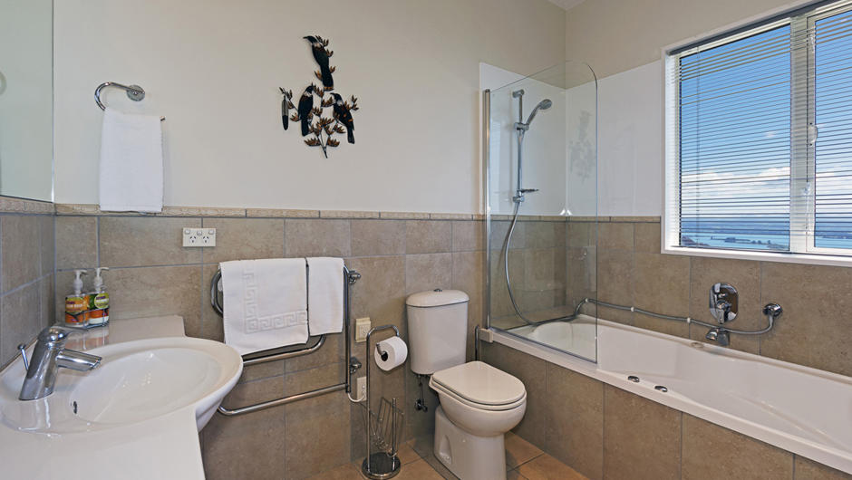 Bathroom with Shower over Bath, Toilet &amp; Basin.