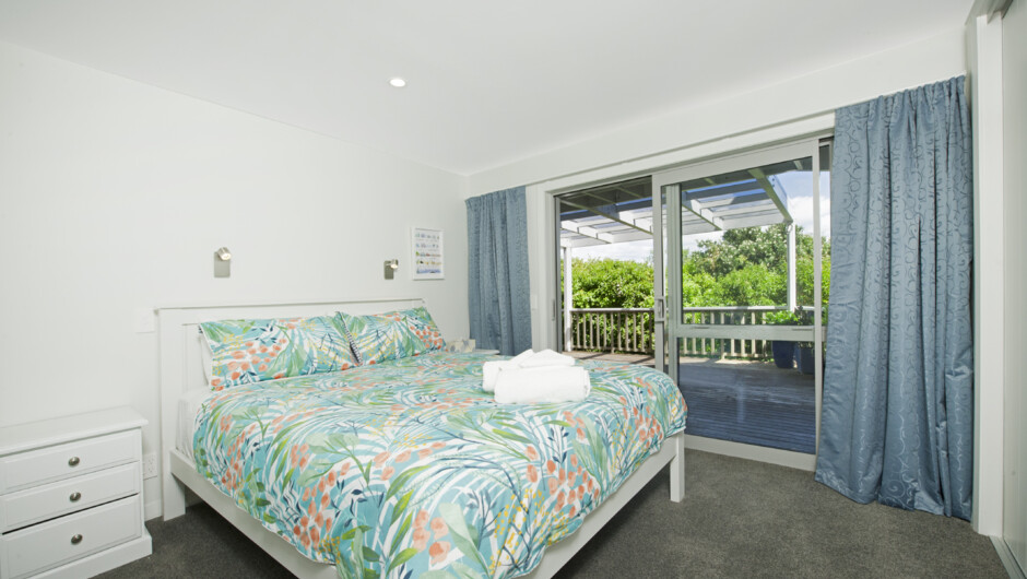 Bedroom 2 (Downstairs) with King bed, garden views. Opens to spa deck.