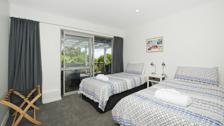 Bedroom 3 (Downstairs) with Single beds x 2, garden views. Opens to spa deck.
