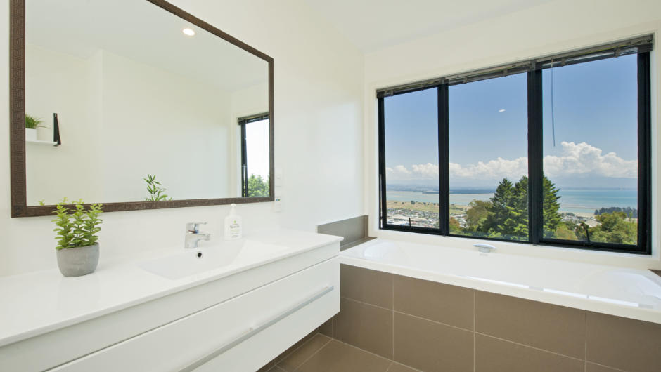 The main bathroom is tiled with underfloor heating, window-side waterfall tap bathtub, separate Shower, Toilet & Vanity.