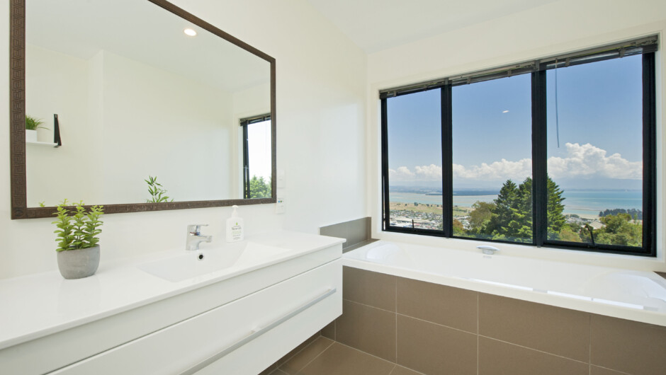 The main bathroom is tiled with underfloor heating, window-side waterfall tap bathtub, separate Shower, Toilet & Vanity.