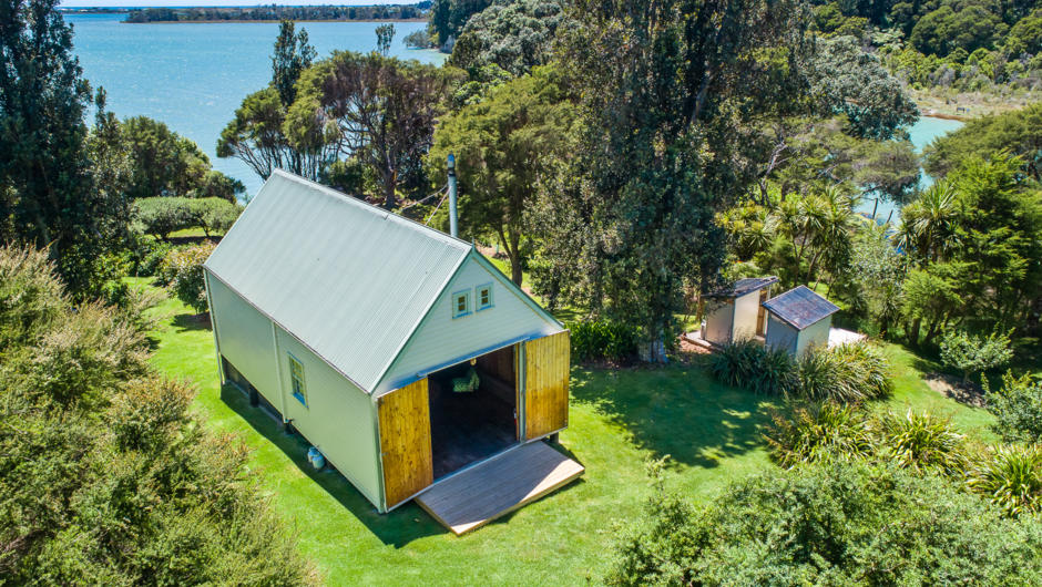 Wainui Seaside Glamping Barn: stunning native bush and sea views nestled within a private hidden valley.