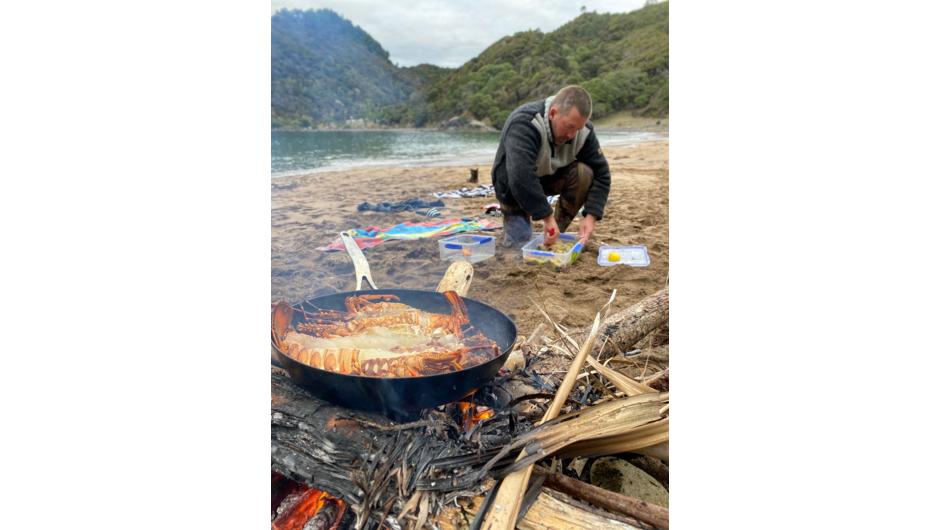 Cooking in nature on our Mens Wellbeing Retreats. Lunch cooked over the fire from New Zealand kumara and kaimoana collected fishing and diving that morning.