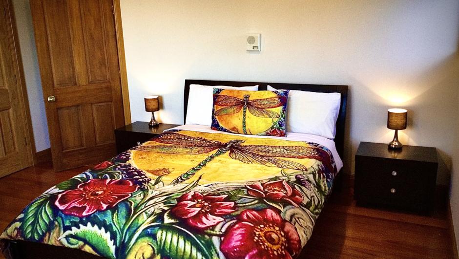 Typical Queen sized bed in large room with stunning views of the valley and native forest.