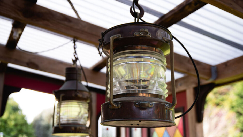 Nautical antiques adorn the cottage. Ship lights illuminate the patio at night.