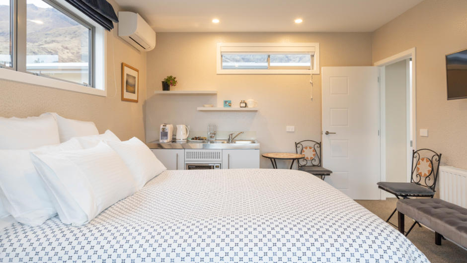 Queen size bed at Stay in Queenstown.  Kitchenette with complementary tea and coffee making.  Milk provided.