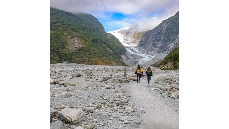 People walking towards Franz Josef Glacier