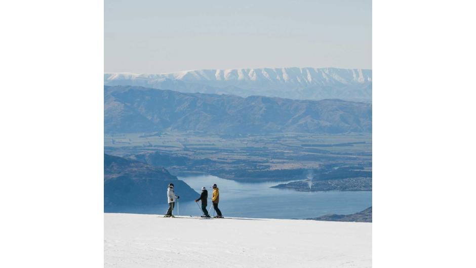 Three skiers at Treble Cone enjoying the fantastic view over Lake Wanaka.