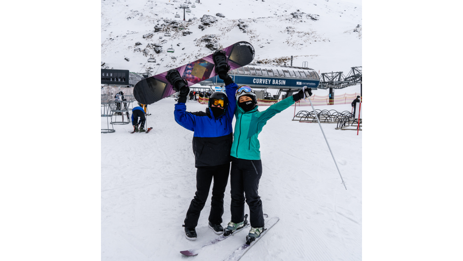 A happy snowboarder and skier feeling accomplished after a day learning the ropes up the Remarkables.