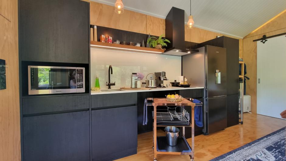 Fully equipped kitchen featuring: A large fridge/freezer, espresso coffee machine, electric ceramic cooktop, outdoor BBQ/grill doubles as a gas oven. All kitchen equipment to cook your own self catered meals, microwave and extractor.